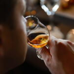 Man,Tasting,Cognac,Holding,Glass,Close,To,Nose,Smelling,The