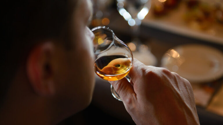 Man,Tasting,Cognac,Holding,Glass,Close,To,Nose,Smelling,The